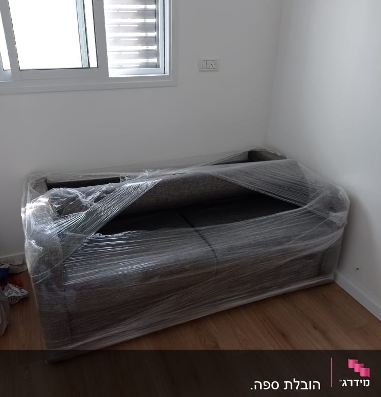 ספה עטופה בניילון נצמד בחדר ריק